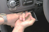 Фото 1. Пальцем отжимаем верх водительского бардачка.